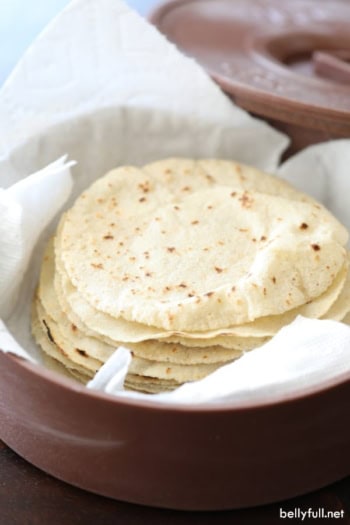 stack of homemade corn tortillas in tortilla warmer