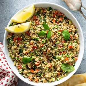 overhead picture of Tabbouleh in white bowl with lemon wedges