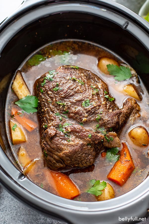 cooked chuck roast in crock pot with vegetables