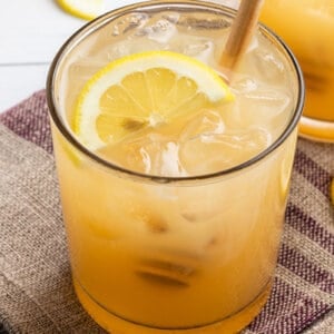 Bee's Knees drink with half moon lemon slice and honey drizzler