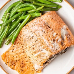 crab stuffed salmon fillet on plate with green beans