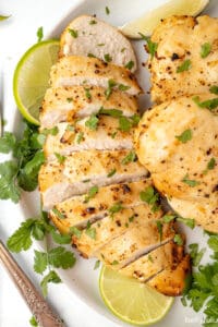 Overhead view of air fryer margarita chicken on a white plate, with one breast cut into slices