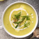 overhead cup of asparagus soup garnished with fresh dill
