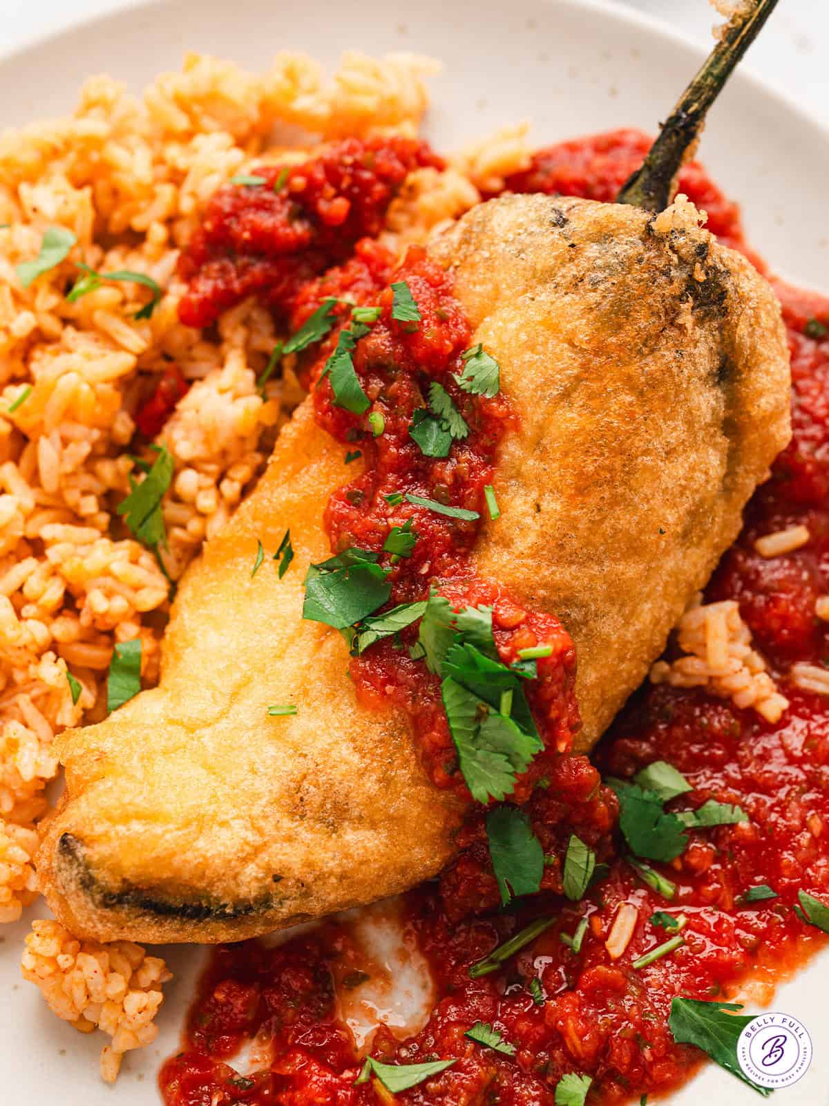 close up Chile Relleno fried stuffed peppers with red sauce