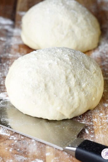 round of pizza dough on cutting board